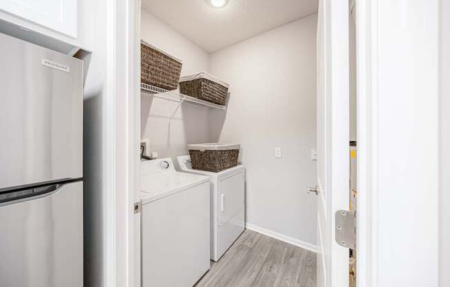 A white refrigerator is on the left of a small kitchen.