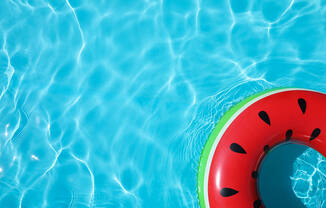 A watermelon-shaped float in a pool of water.