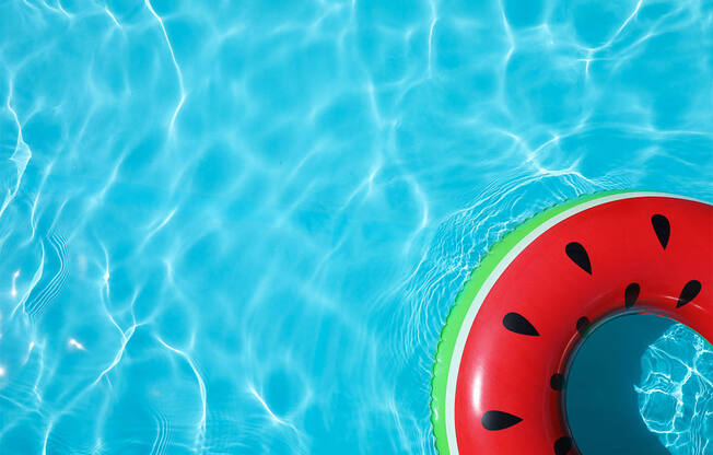A watermelon-shaped float in a pool of water.
