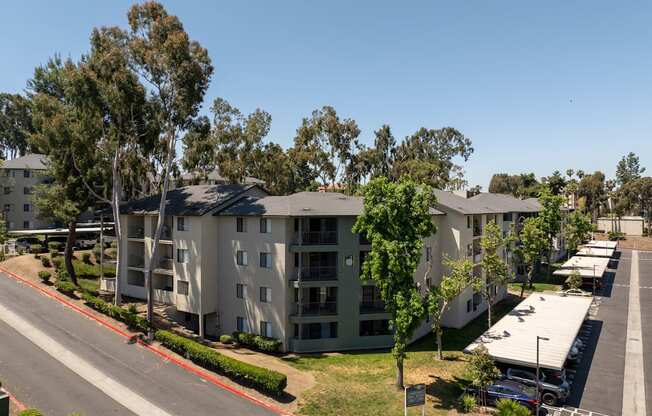 an aerial view of an apartment complex with trees and a street