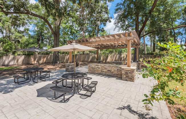 a patio with a pergola and tables with umbrellas