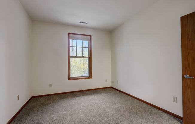 an empty room with white walls and a window