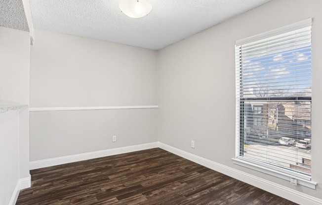 A room with a window and wooden flooring.