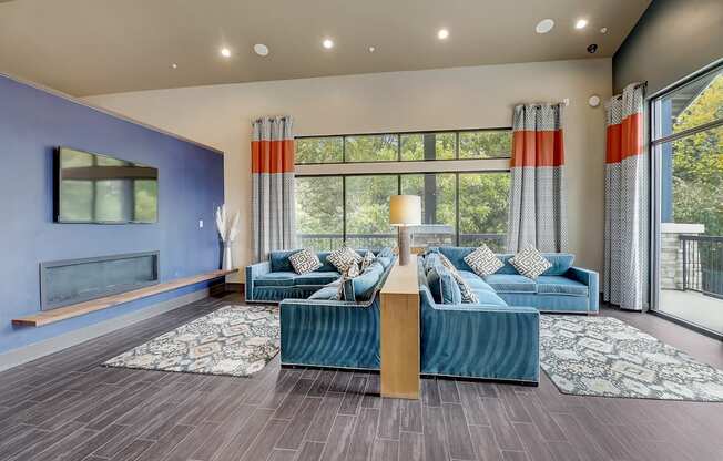 a living room with blue couches and a large window