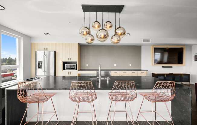 a kitchen with a large center island with a breakfast bar and copper bar stools at Ion Town Center, Washington