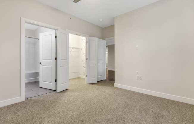 an empty bedroom with two closets and a bathroom