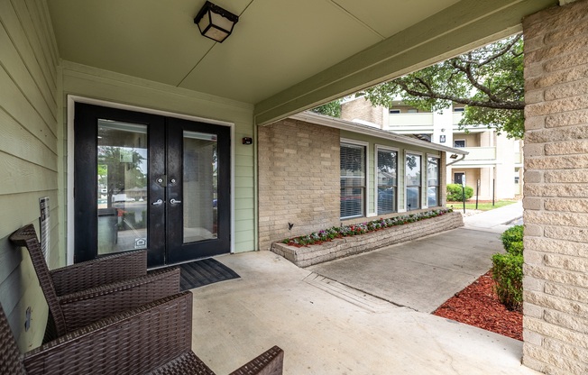 front porch of a house with two chairs and a patio