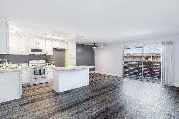 A spacious kitchen with white appliances and a large island.