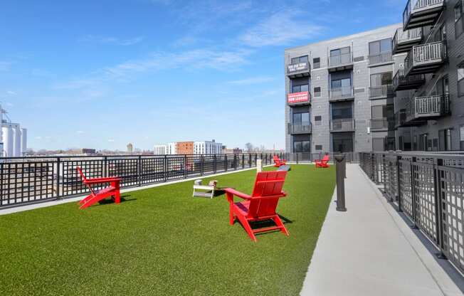 chairs on a roof terrace with grass and a view of the city