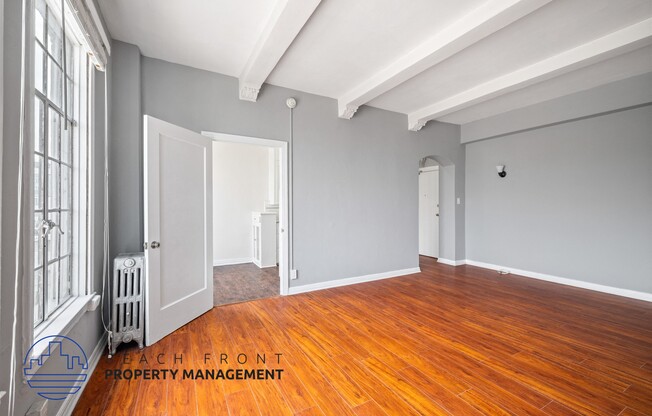 the living room and dining room with wood floors and gray walls