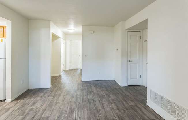 an empty living room with white walls and wood flooring