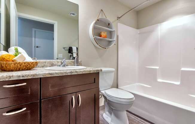 a bathroom with a toilet sink and bathtub at Allora Phoenix Apartments, Arizona