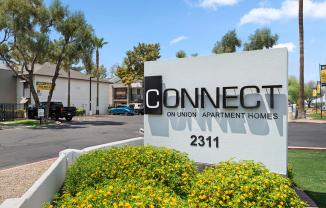 a sign for connect on union apartment homes is in front of a building