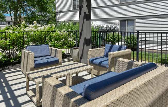 a patio with chairs and a table and a umbrella