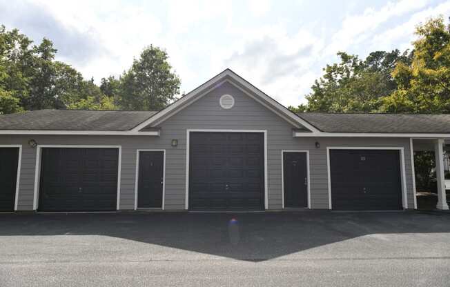 the front of a gray garage with three garage doors