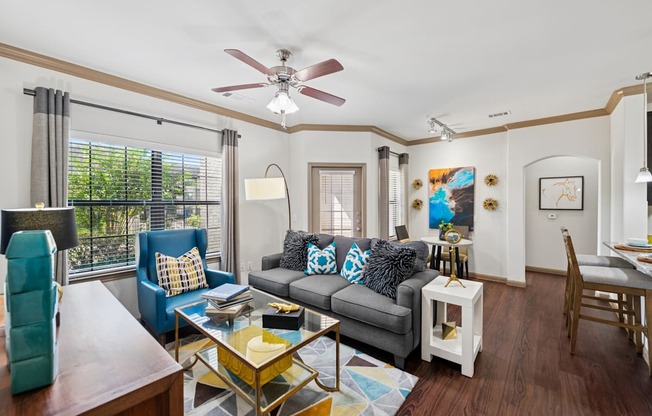 A living room with a grey couch and a yellow coffee table.