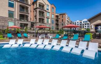 loungers in pool and umbrellas with chairs