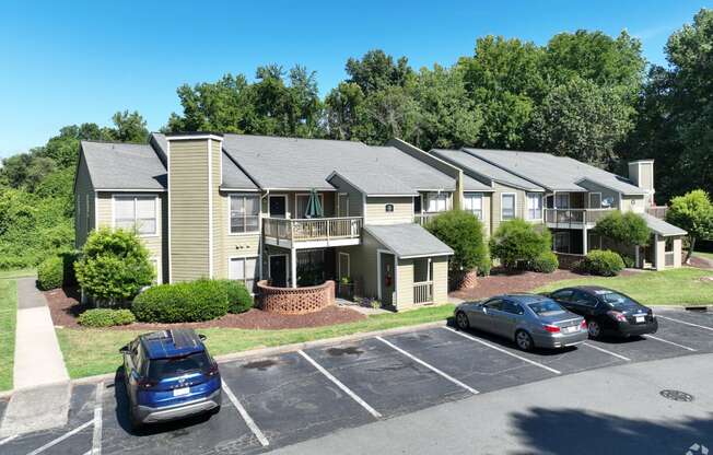 an aerial view of an apartment complex with cars parked in a parking lot