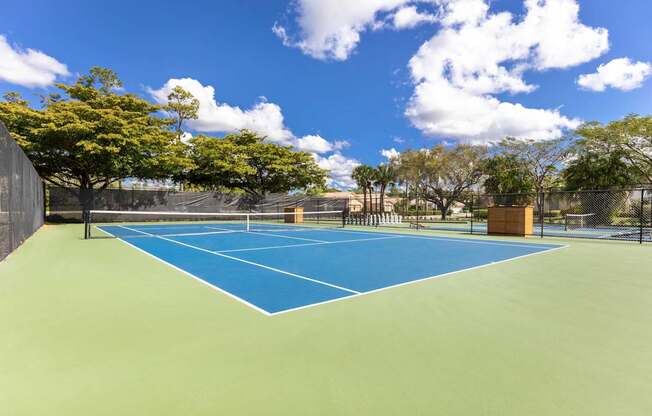 A tennis court with a blue surface and white boundary lines.