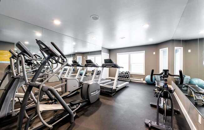 A gym with treadmills, exercise bikes, and other equipment.