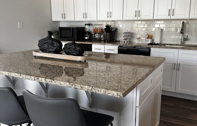 a kitchen with white cabinets and a granite counter top