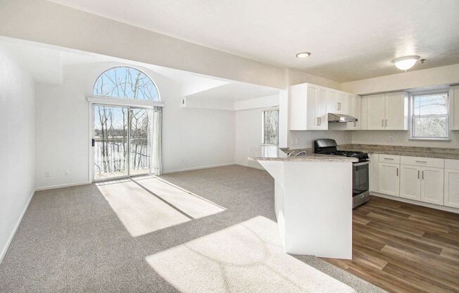 A sunny day in a spacious, end style living room with a cathedral ceiling and kitchen at Brentwood Park Apartments, La Vista, Nebraska