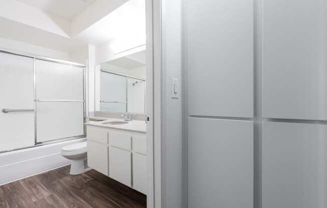 a white bathroom with a shower toilet and sink