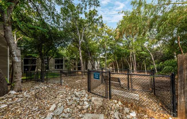 Large woodsy dog park at Hillside Creek Apartments in Austin, TX