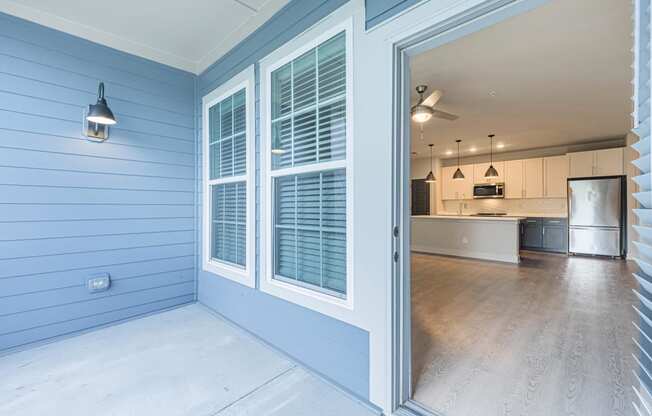 a view of the kitchen from the porch of a blue house
