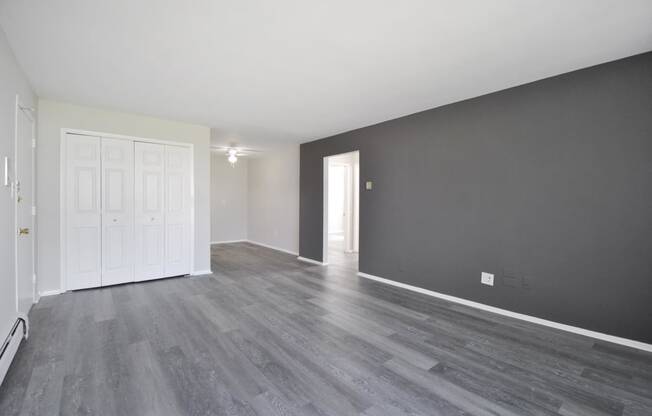 the living room and dining room of a house with grey walls and white doors