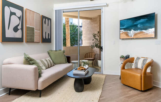 A living room with a couch, chair, and artwork on the wall.