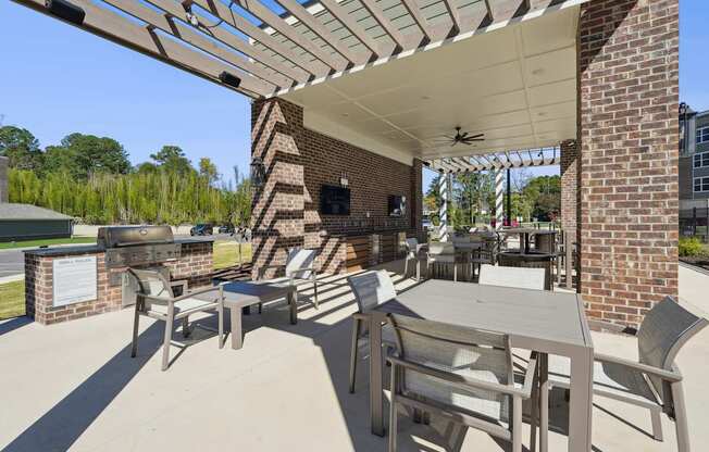 A patio with a table and chairs under a roof.