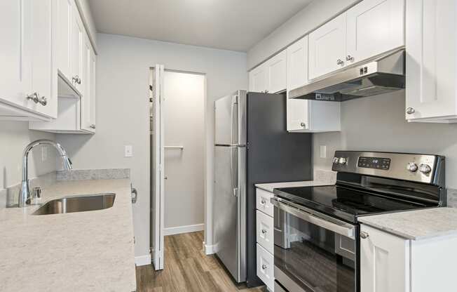 a kitchen with stainless steel appliances and white cabinets