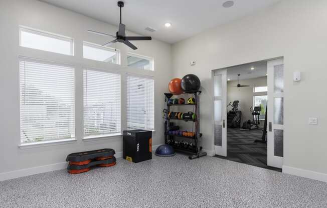 a living room with a large window and a ceiling fan