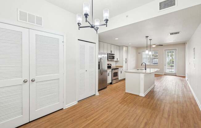 A kitchen with white cabinets and a wooden floor.