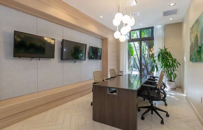 Conference room with hanging pendants and three mounted televisions on wall