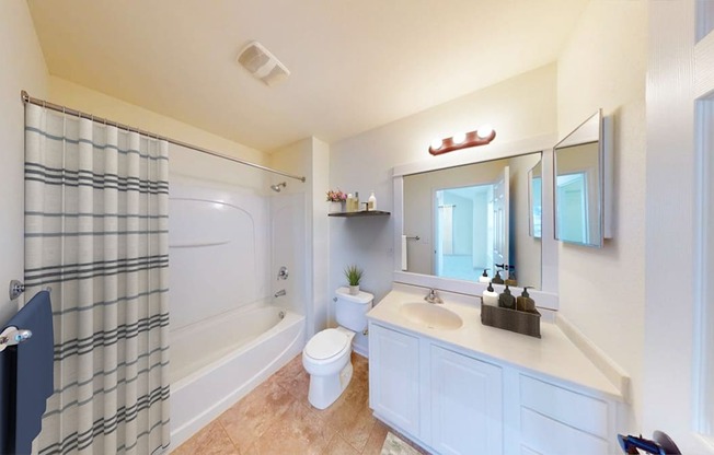 A bathroom with a toilet, sink, and shower.