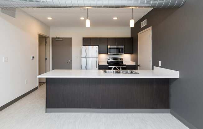 Modern open-concept kitchen and living area with stainless steel appliances.