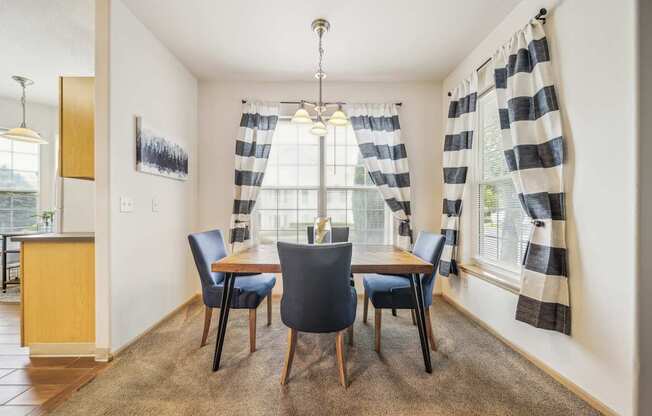 A dining room with a table and chairs.