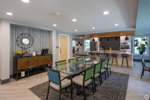 a dining area with a glass table and chairs and a bar