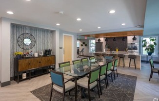 a dining area with a glass table and chairs and a bar