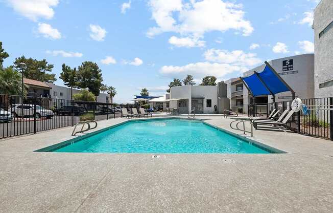 A large swimming pool surrounded by a black fence.