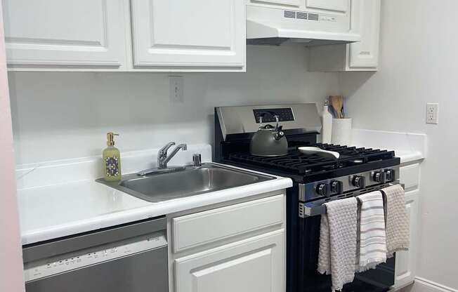 A kitchen with white cabinets and a black stove top oven.