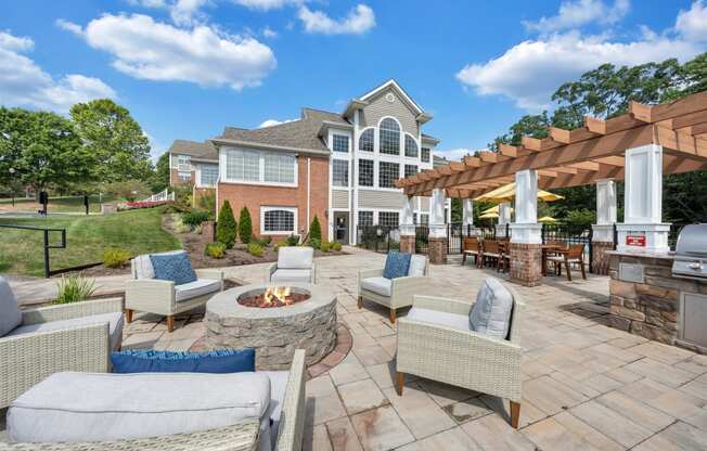 a backyard patio with chairs and a fire pit