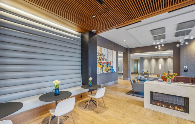a lobby with tables and chairs and a fireplace at The Merc, Massachusetts, 02453