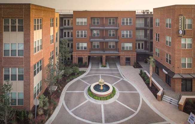 A courtyard with a fountain in the middle of it.