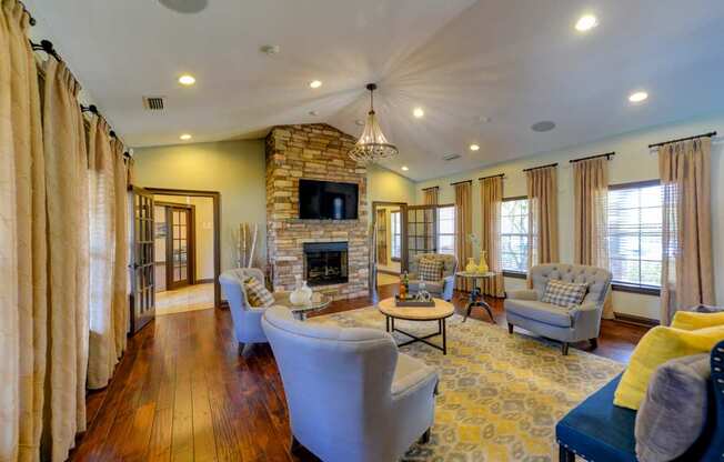 A living room with a stone fireplace and a television above it.