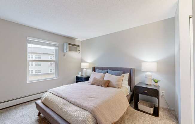 a white bedroom with a large bed and a window