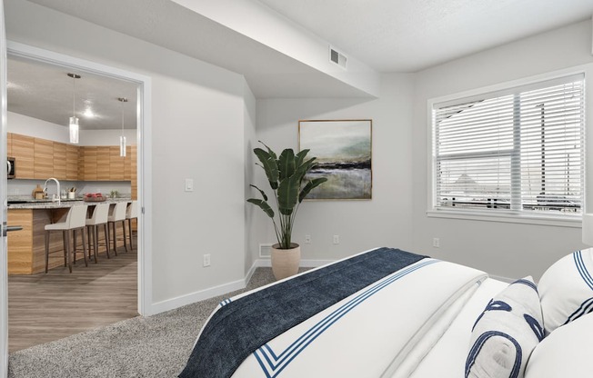 A bedroom with a large bed and a painting on the wall.
