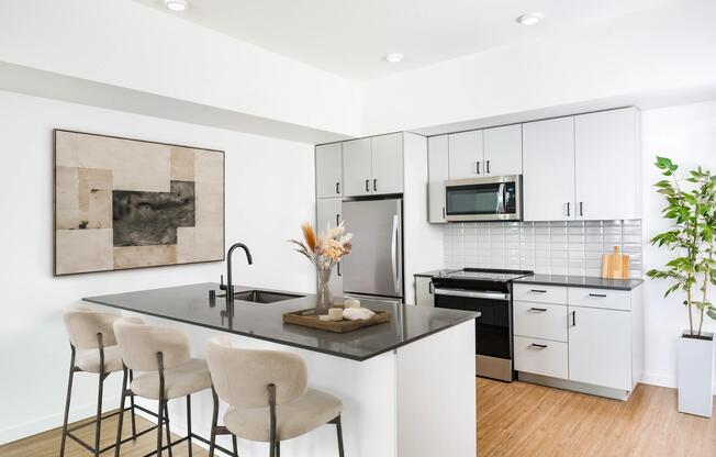 Kitchen with a spacious island, bar seating, and stainless steel appliances set within a bright layout designed for cooking and daily connection.